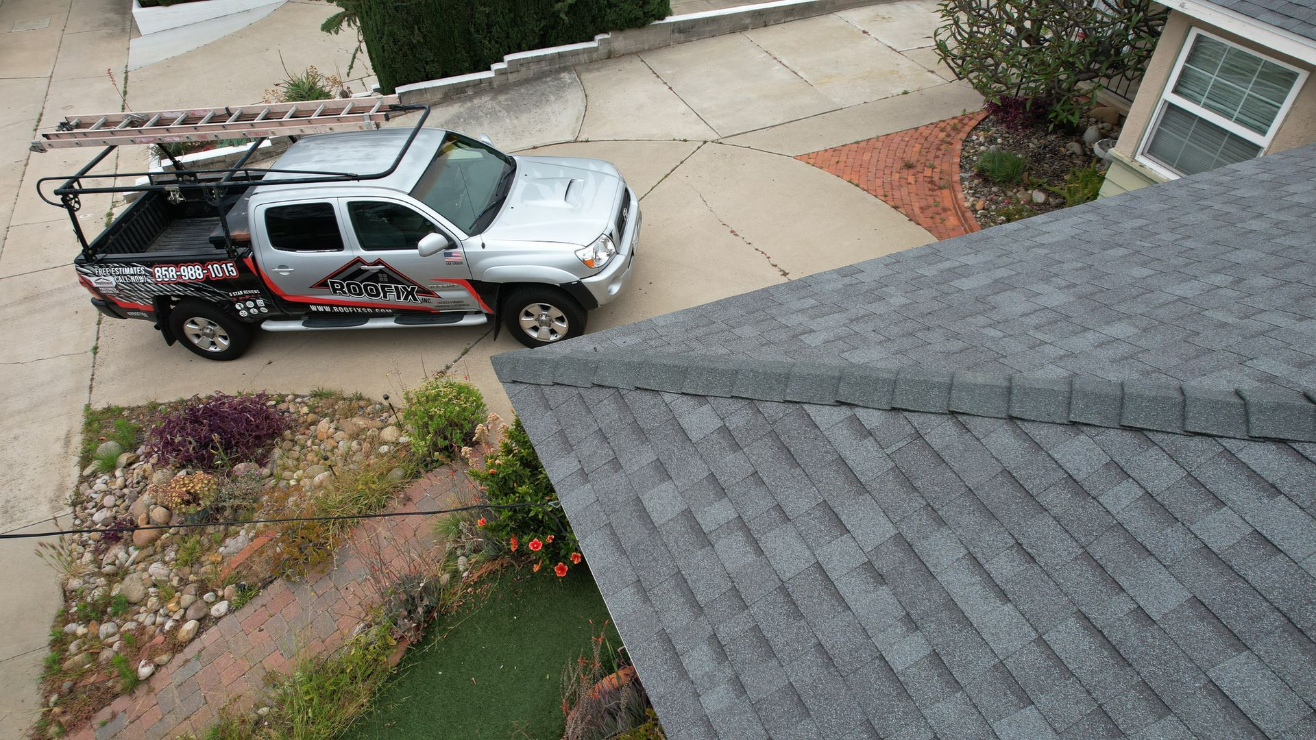 A silver truck is parked on the side of a house