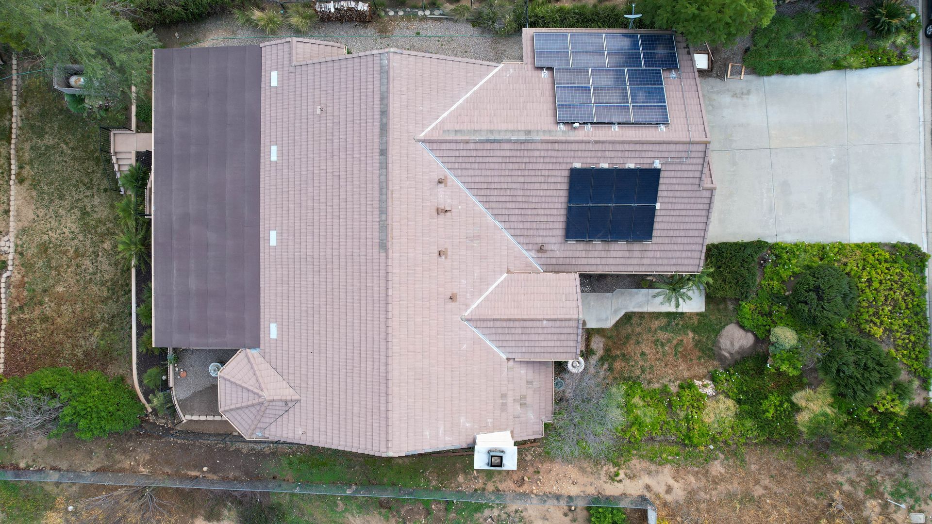 An aerial view of a house with solar panels on the roof