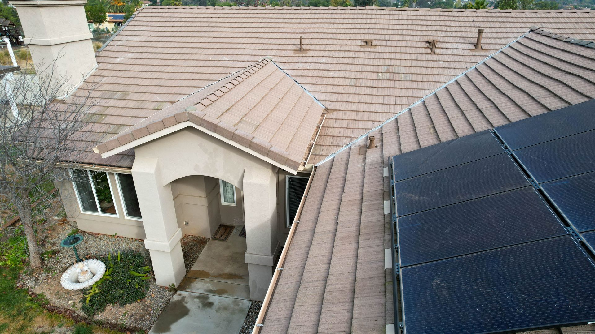 An aerial view of a house with solar panels on the roof