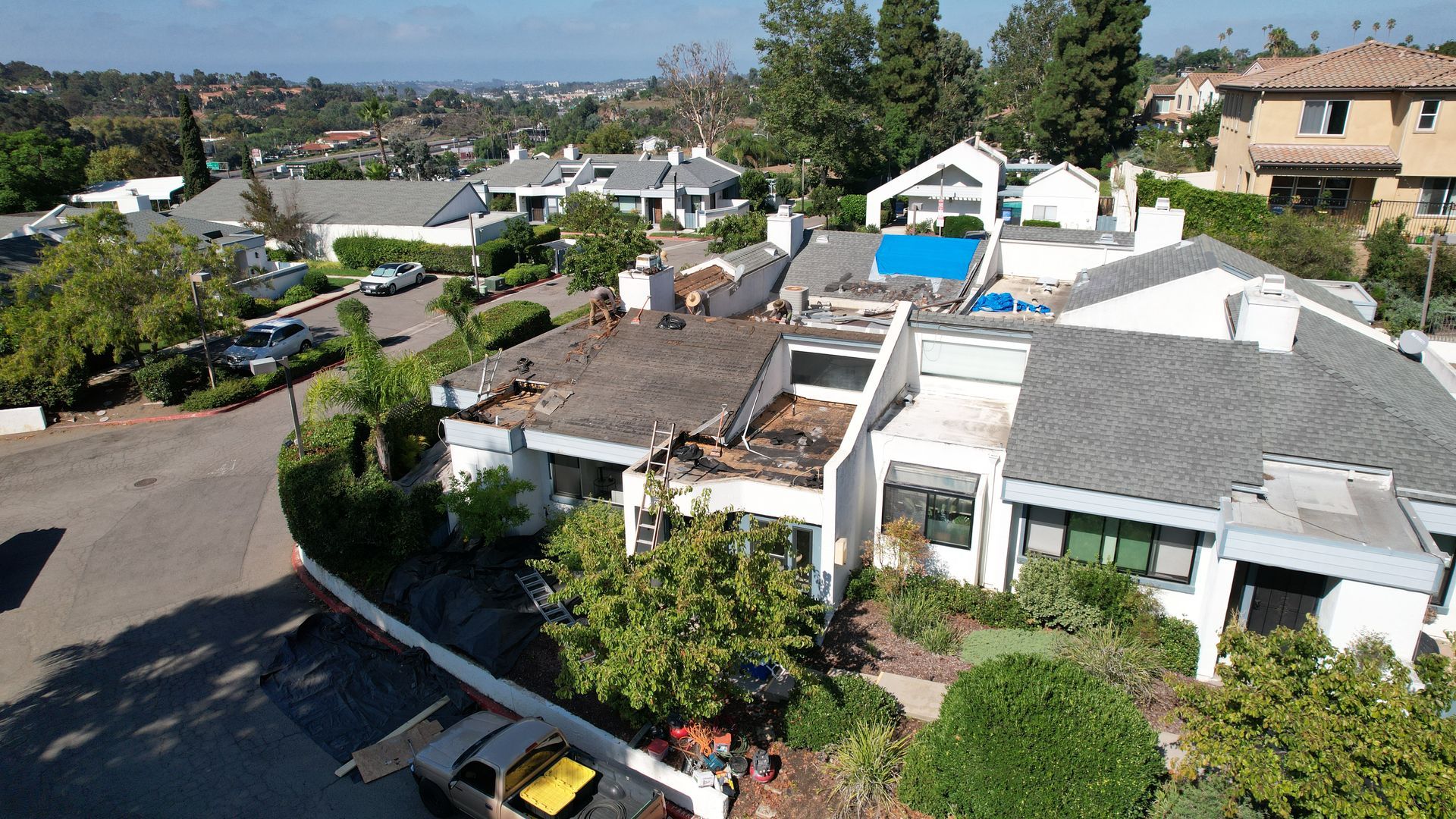 A yellow truck is parked in front of a row of houses