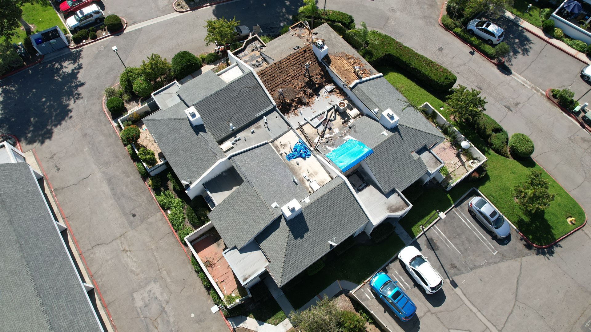 An aerial view of a building with a blue tarp on the roof