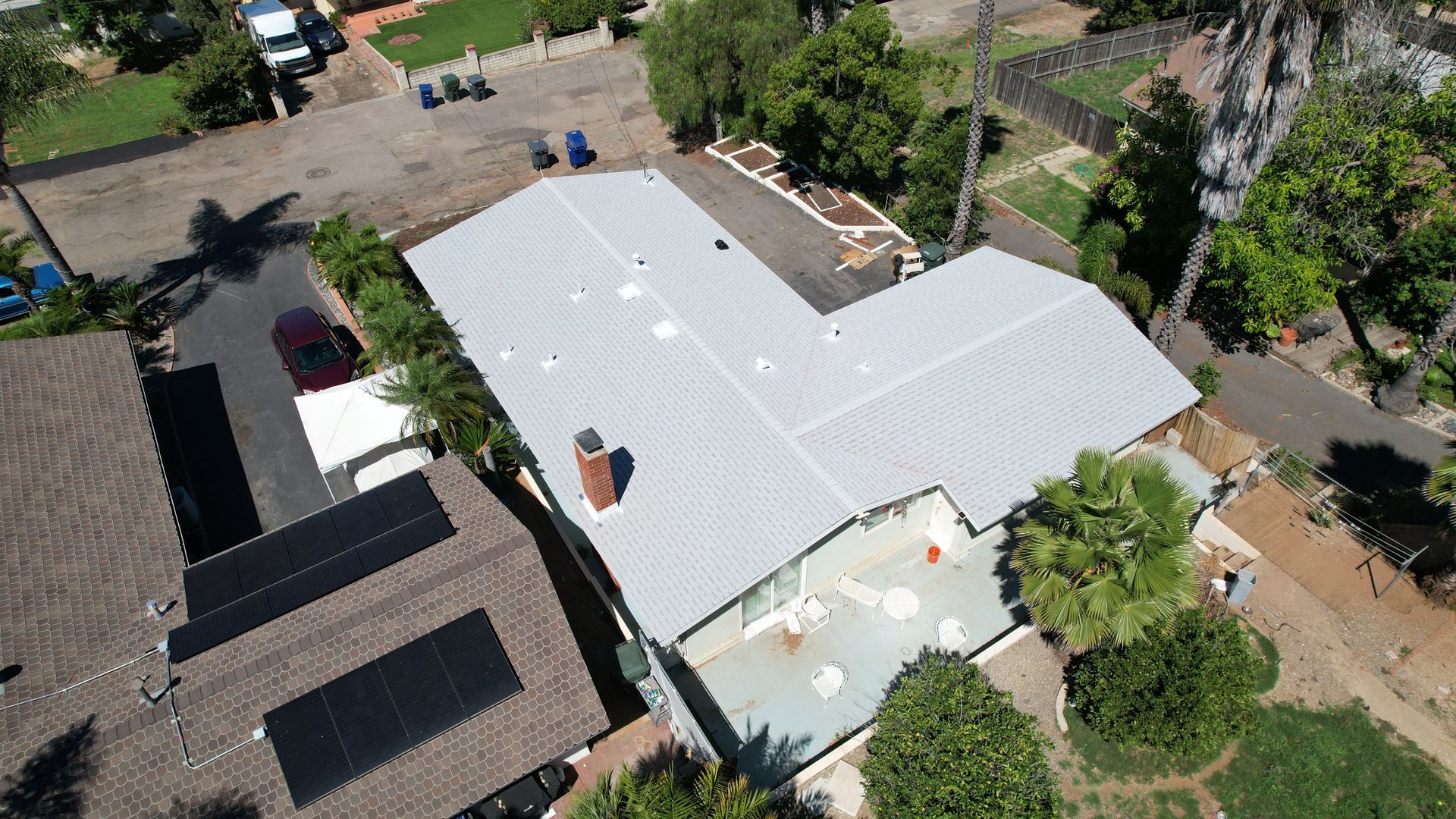 An aerial view of a house with a white roof
