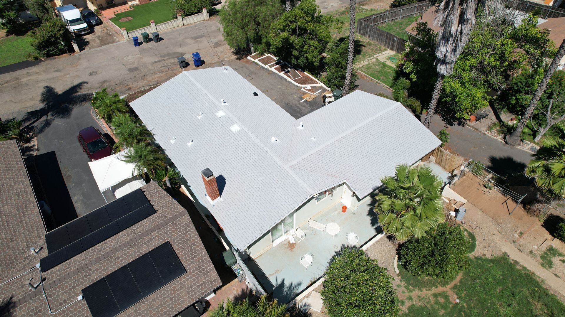 An aerial view of a house with a white roof