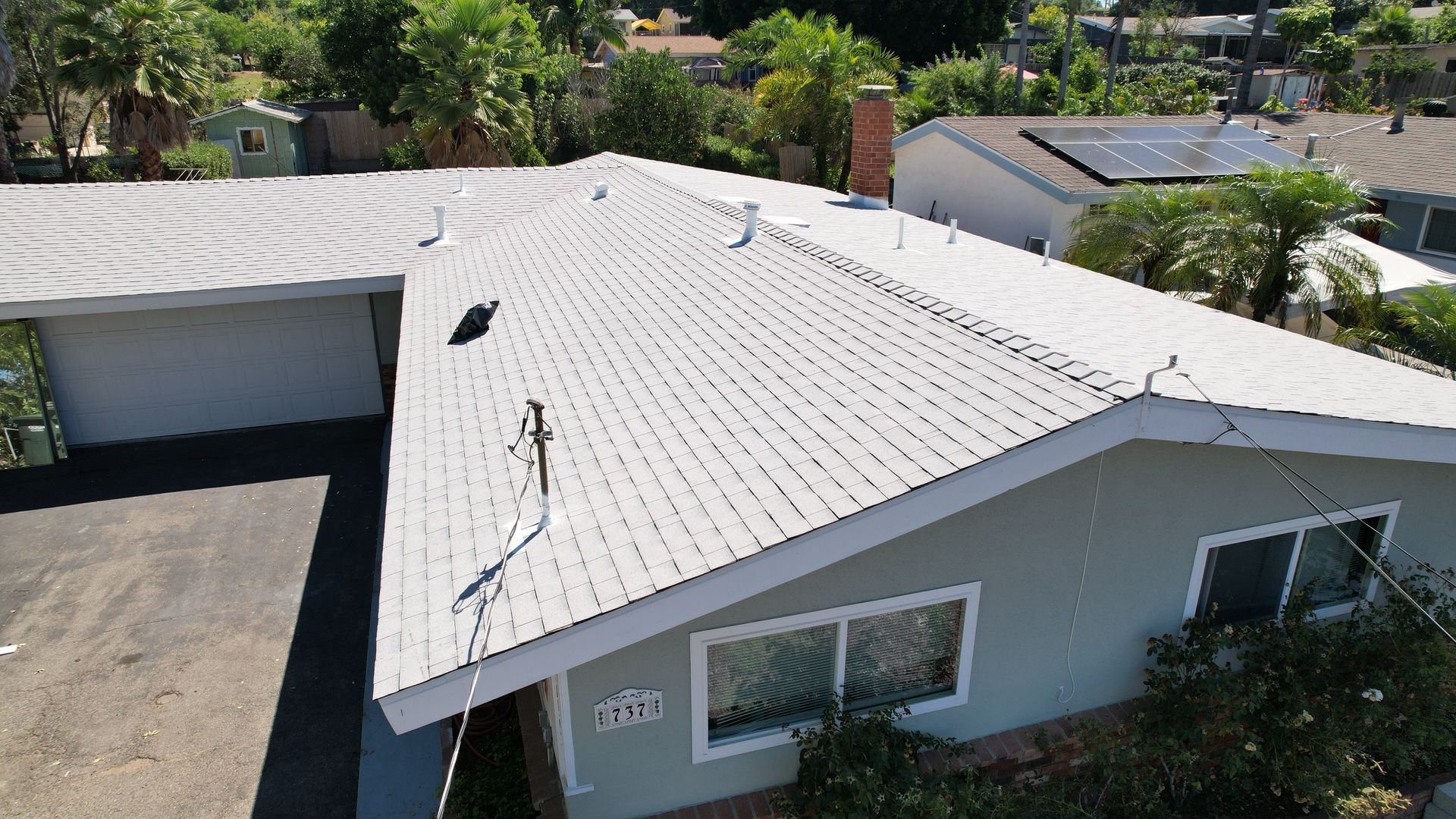 An aerial view of a house with a white roof