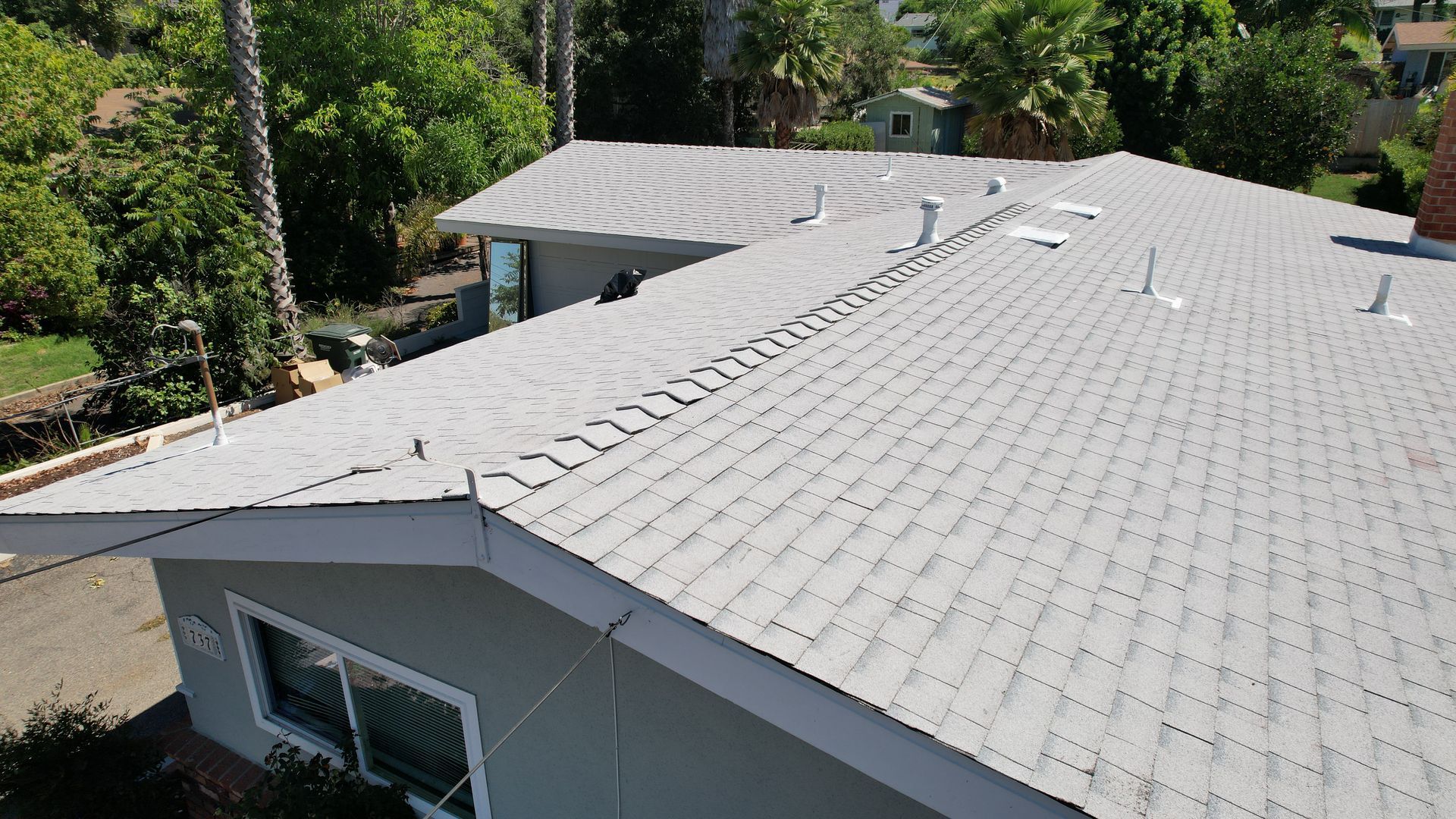 An aerial view of a house with a gray roof