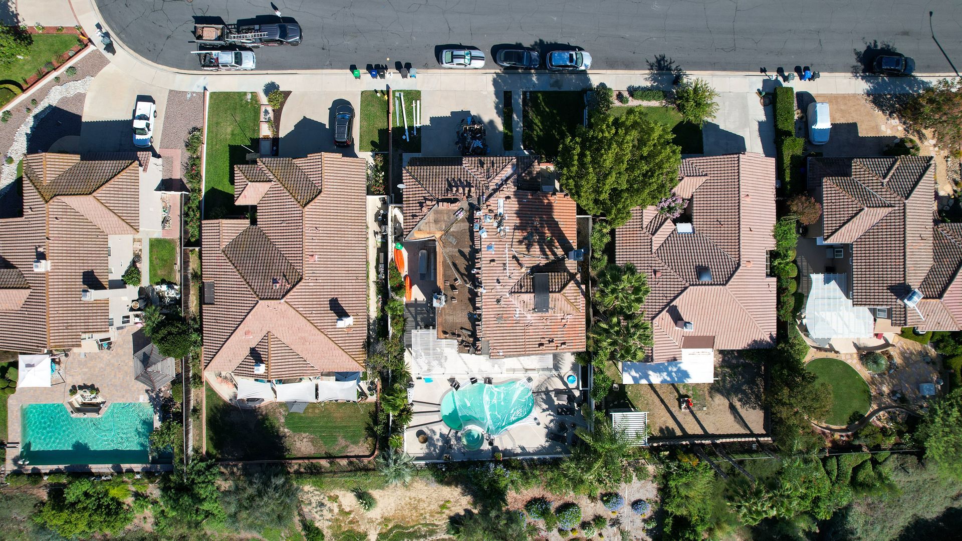 An aerial view of a residential area with houses and a pool