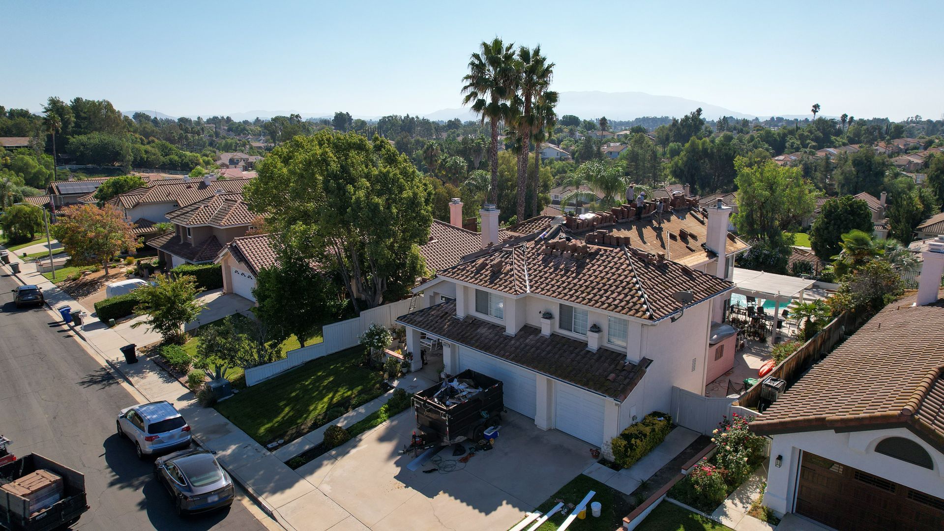 An aerial view of a residential area with a damaged roof