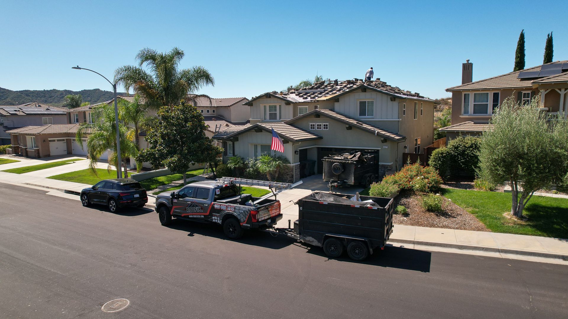 A car is pulling a trailer in front of a house
