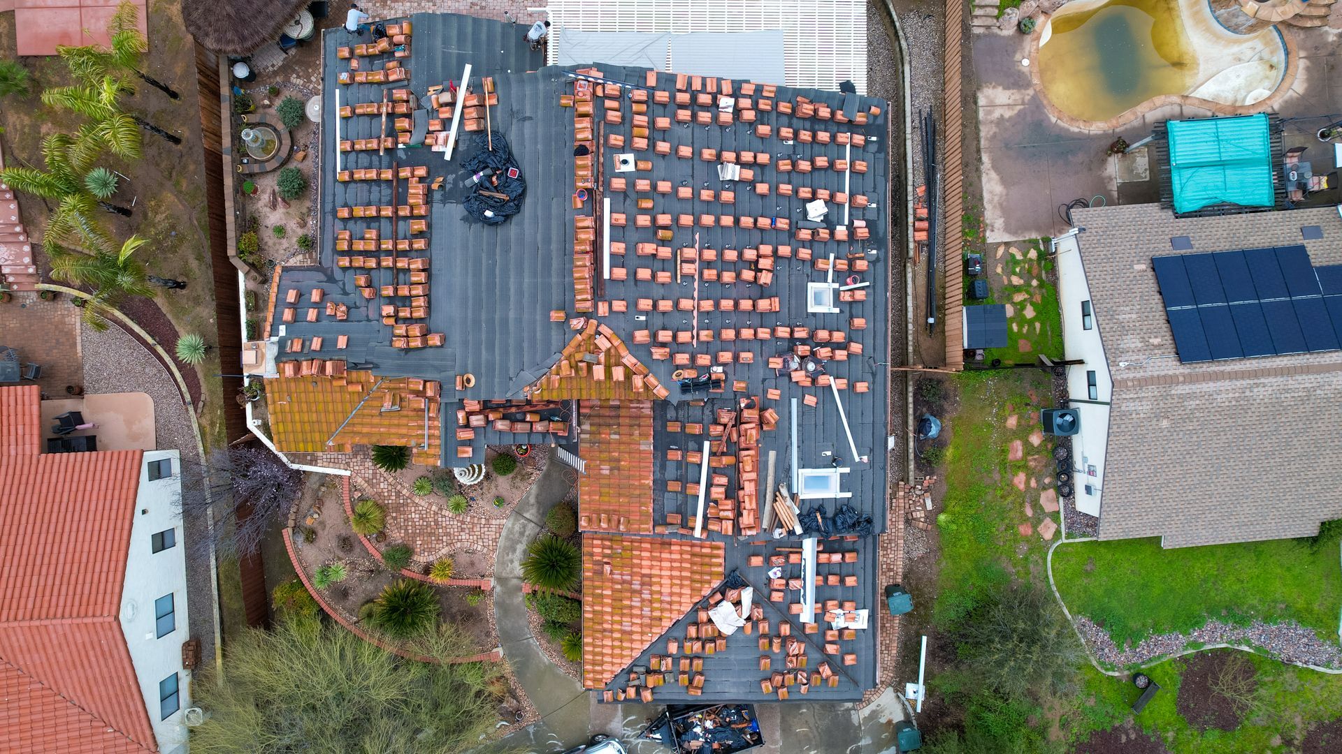 An aerial view of a house with a roof that is being repaired.