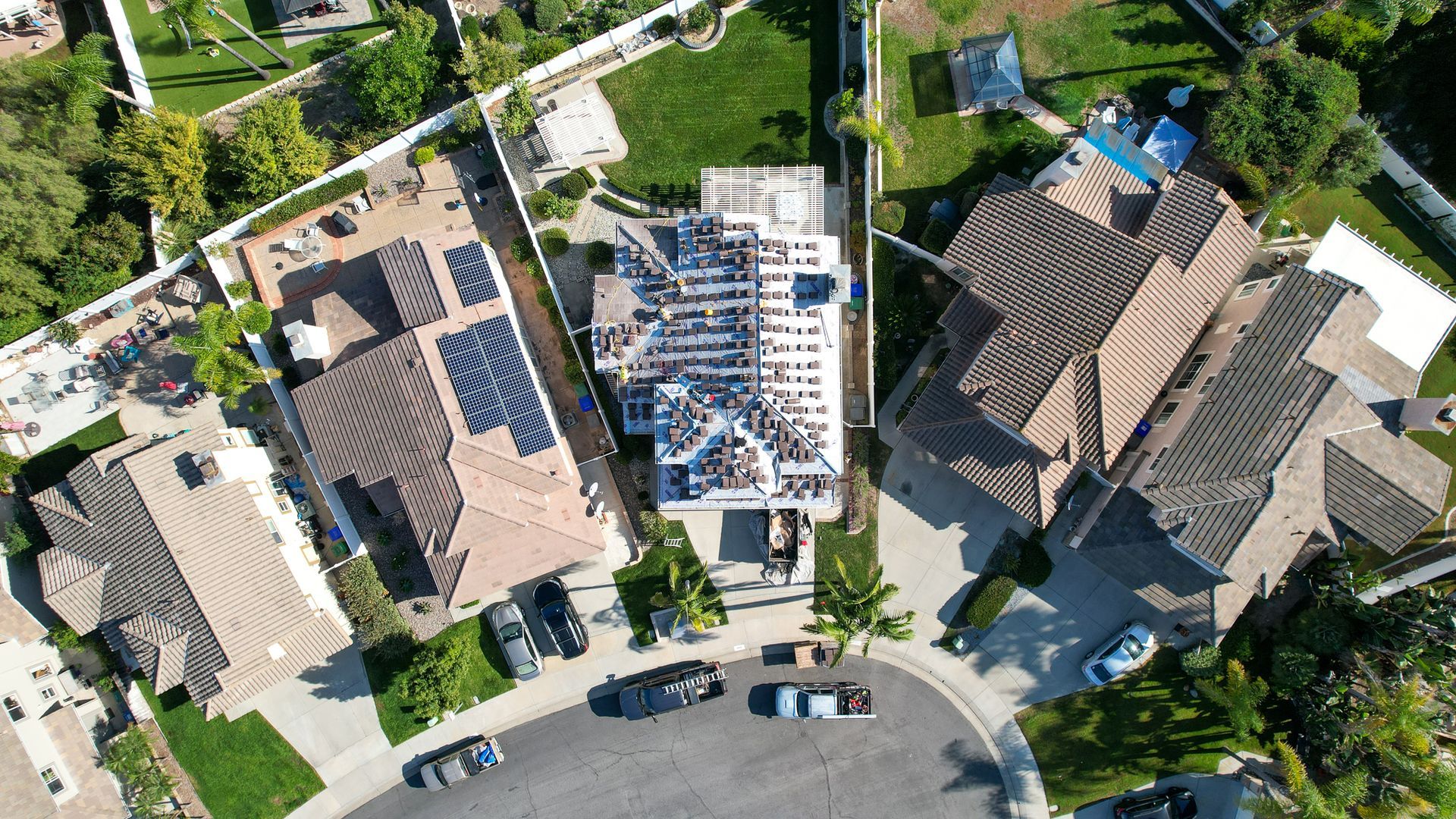 An aerial view of a residential neighborhood with a house under construction
