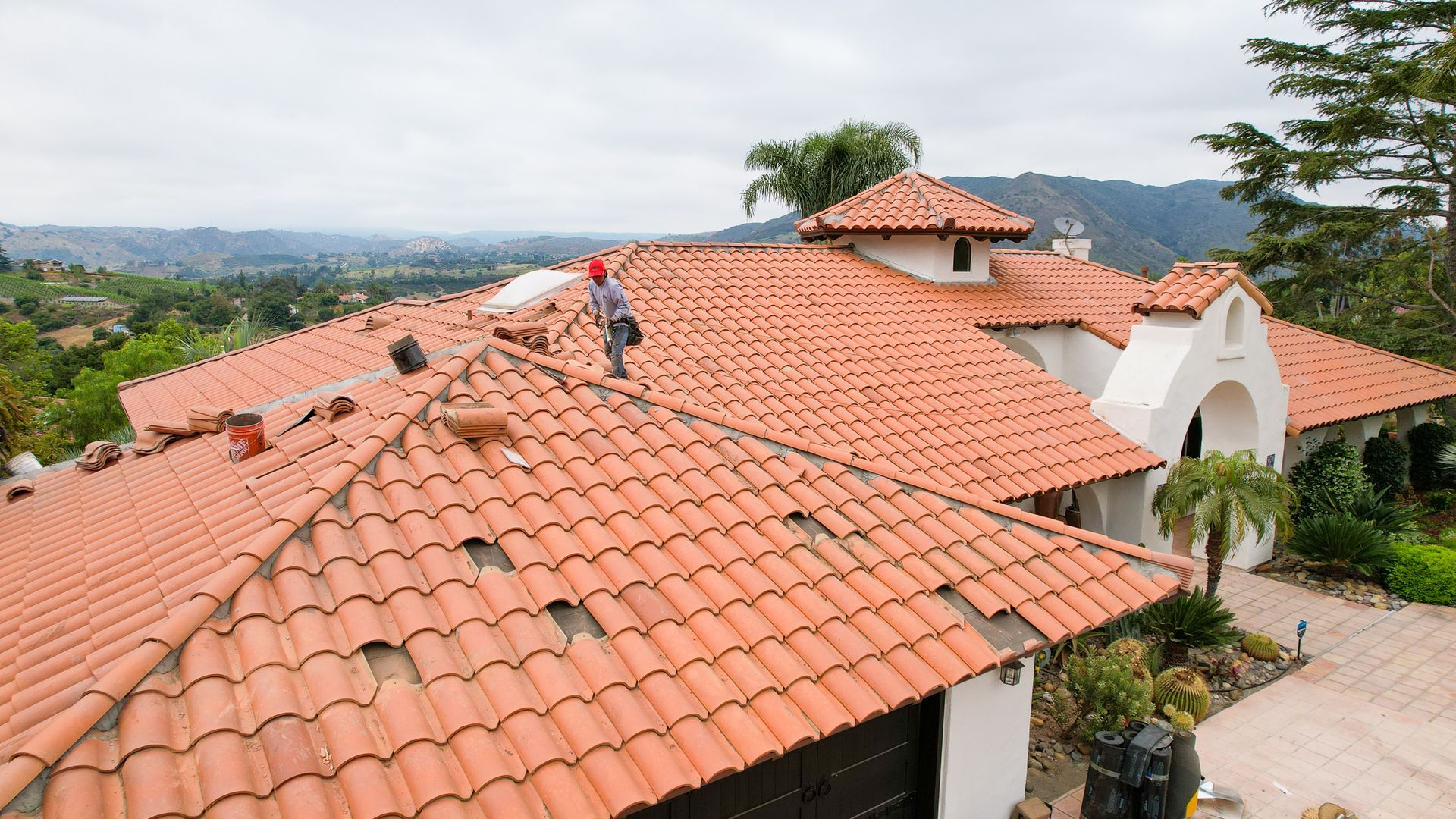 A man is working on the roof of a house