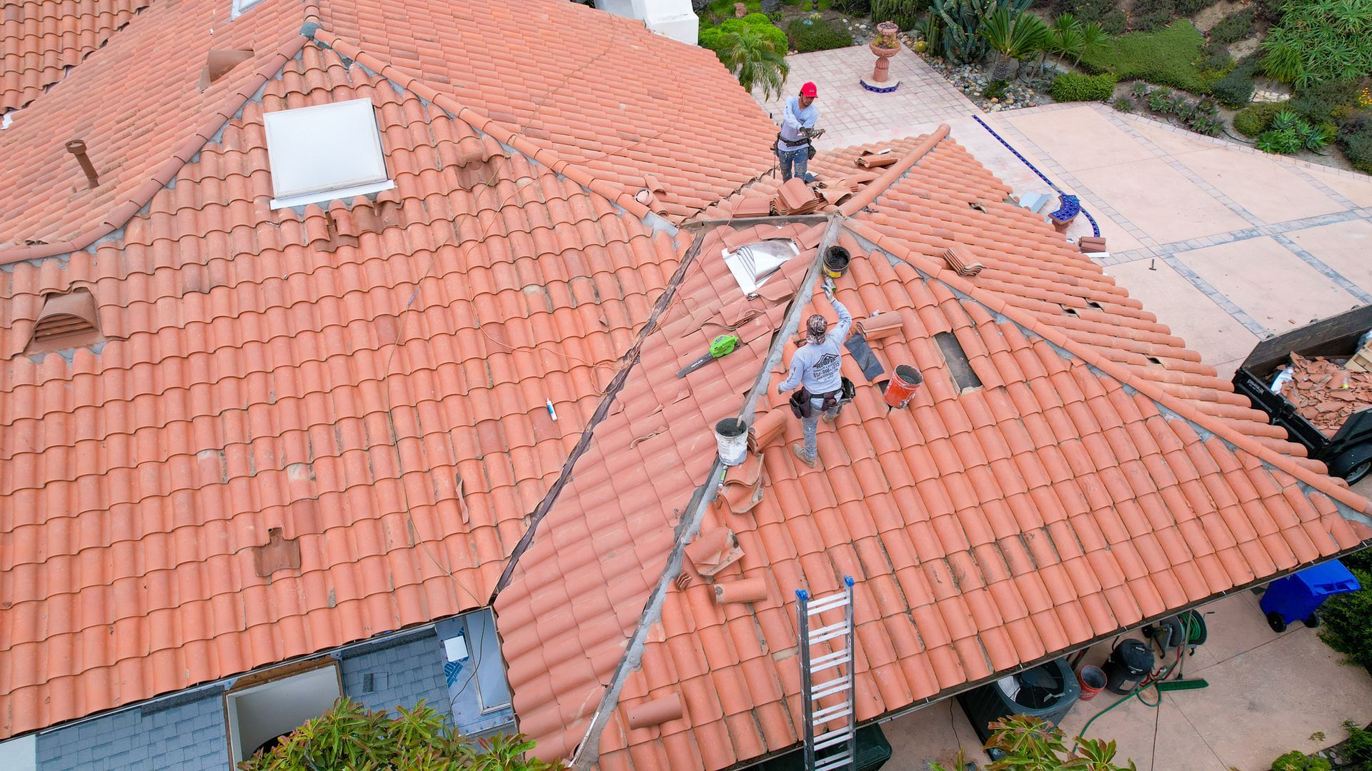 A group of men are working on the roof of a house
