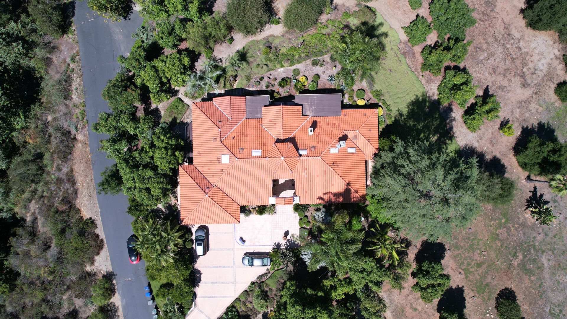 An aerial view of a house with a red tile roof