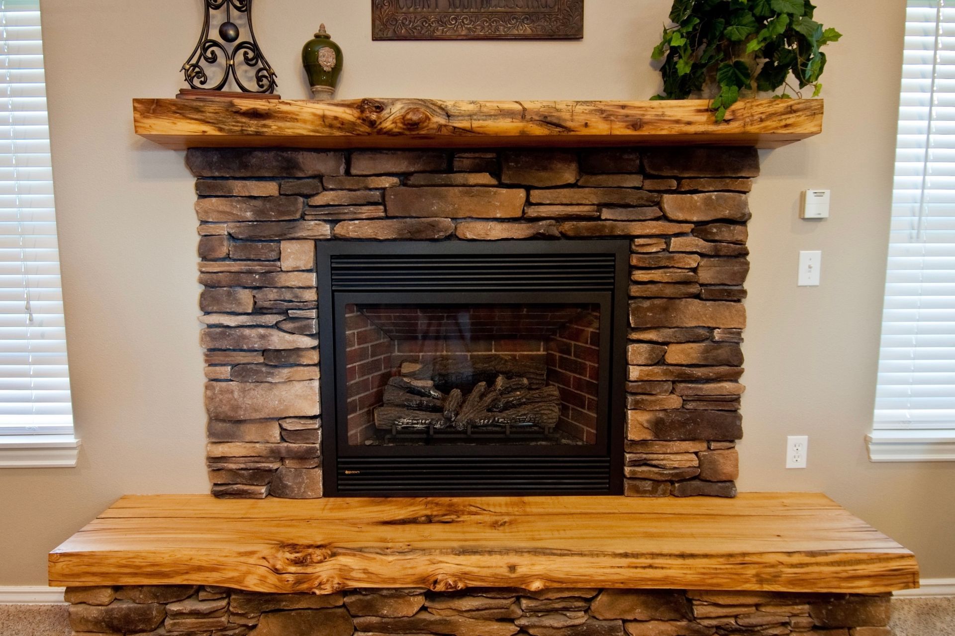 Fireplace with stone surround, wooden mantle and hearth.