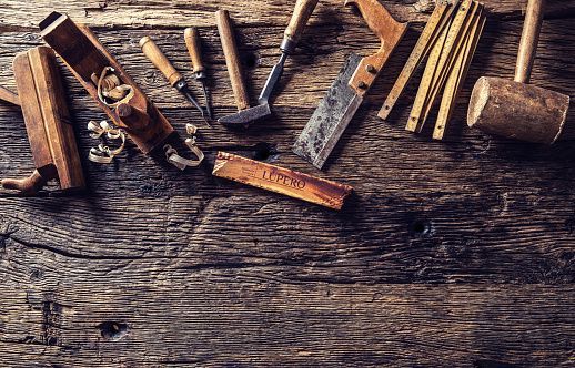 Carpentry tools on weathered wooden surface.