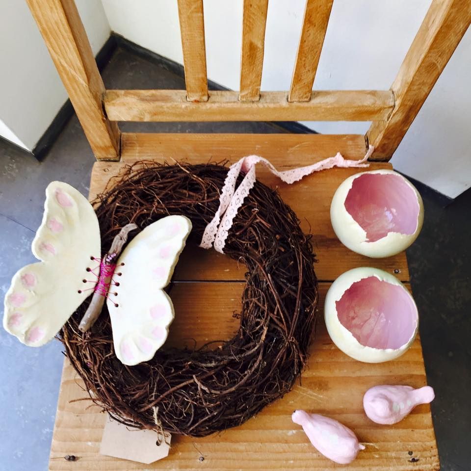 Ein Kranz mit einem Schmetterling darauf sitzt auf einem Holzstuhl