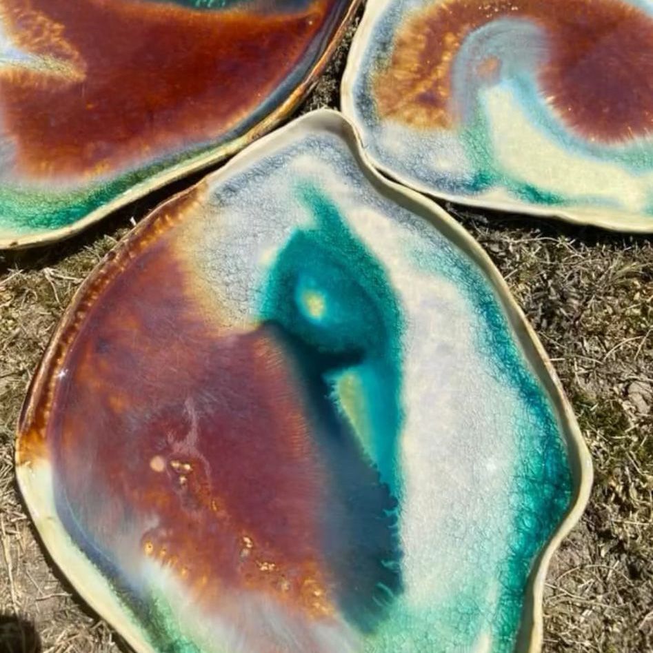 Auf dem Boden liegen drei Teller mit unterschiedlichen Farben.