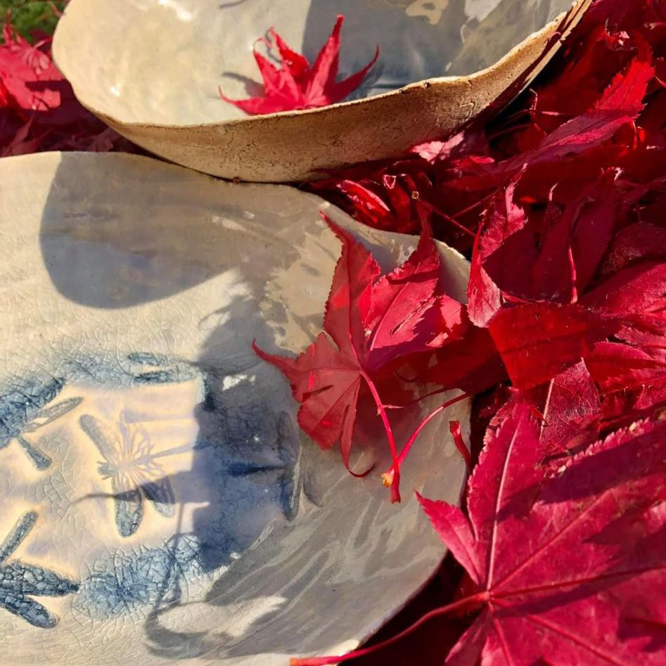 Ein paar Schüsseln auf einem Haufen roter Blätter