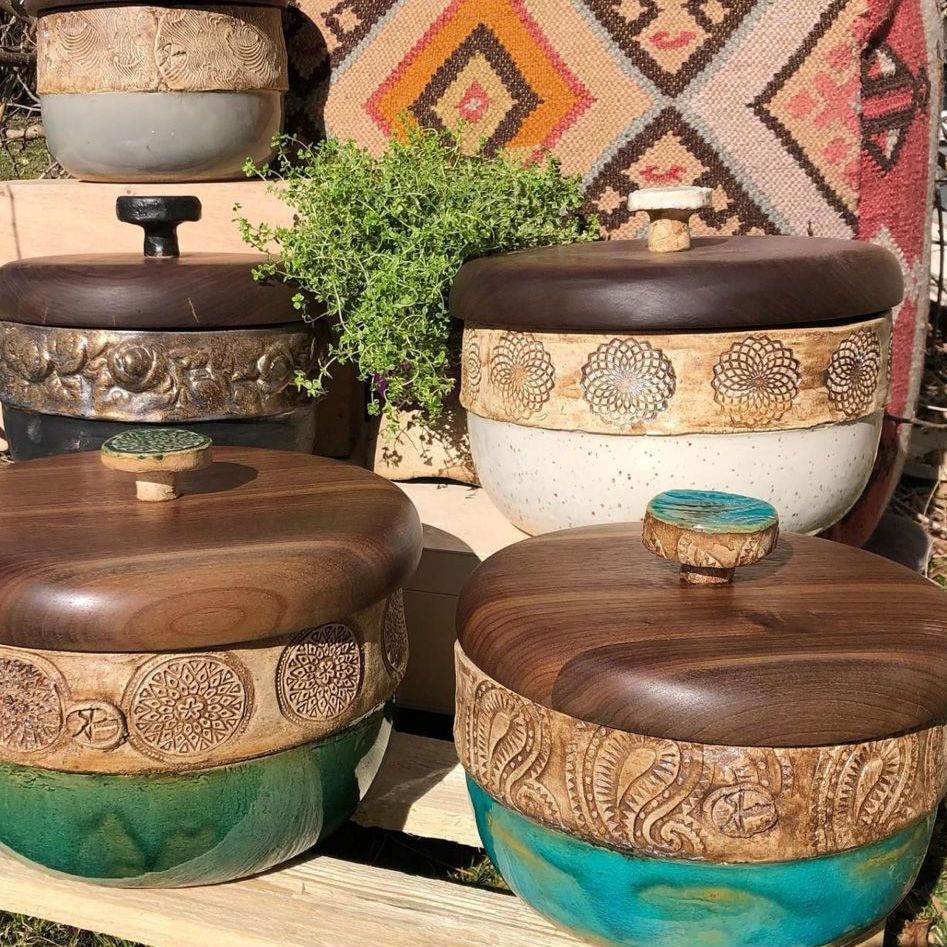 Mehrere Schüsseln mit Holzdeckeln stehen auf einem Holzregal.