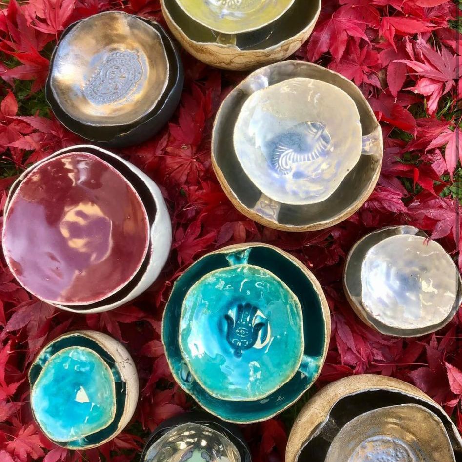 Auf einem Haufen roter Blätter stehen mehrere Schüsseln.