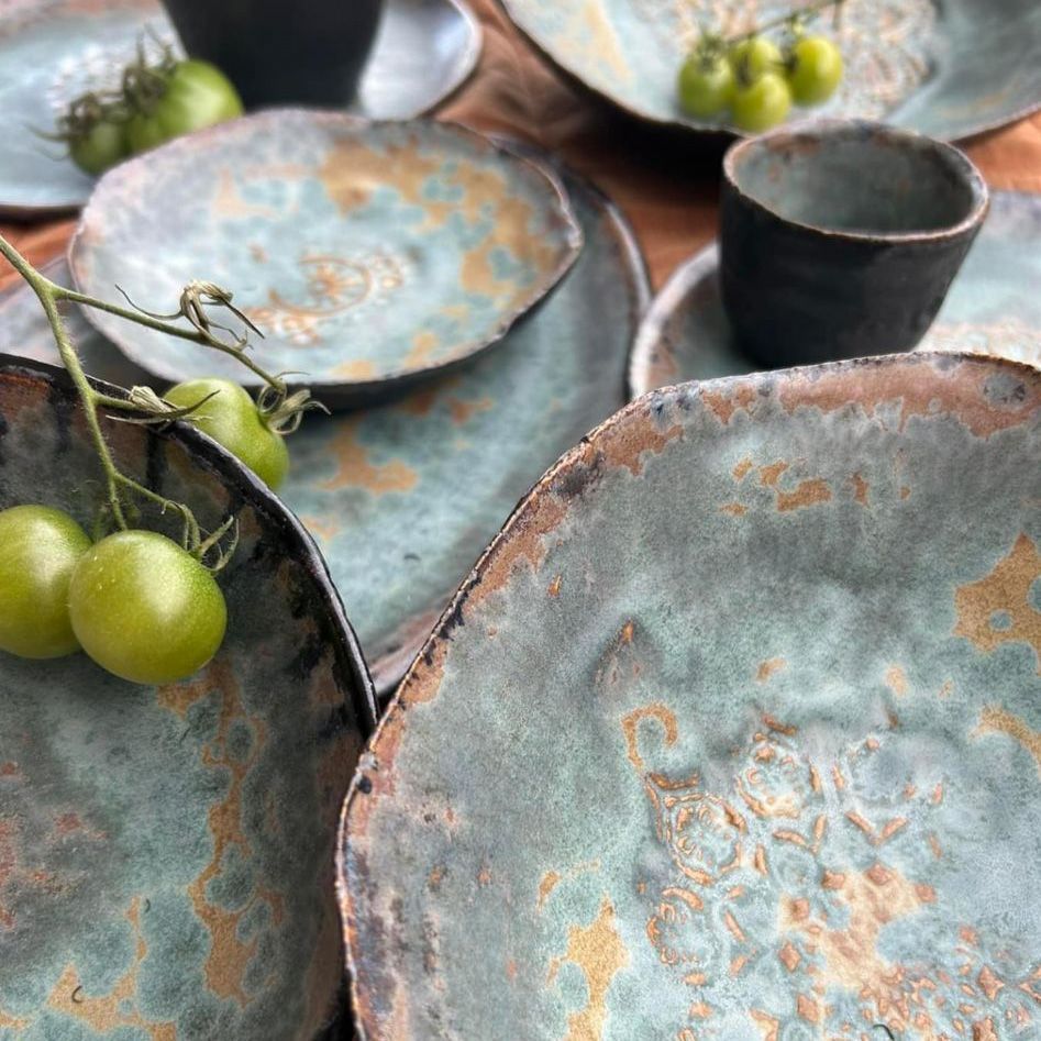 Ein Tisch mit Tellern, Schüsseln, Tassen und Tomaten.