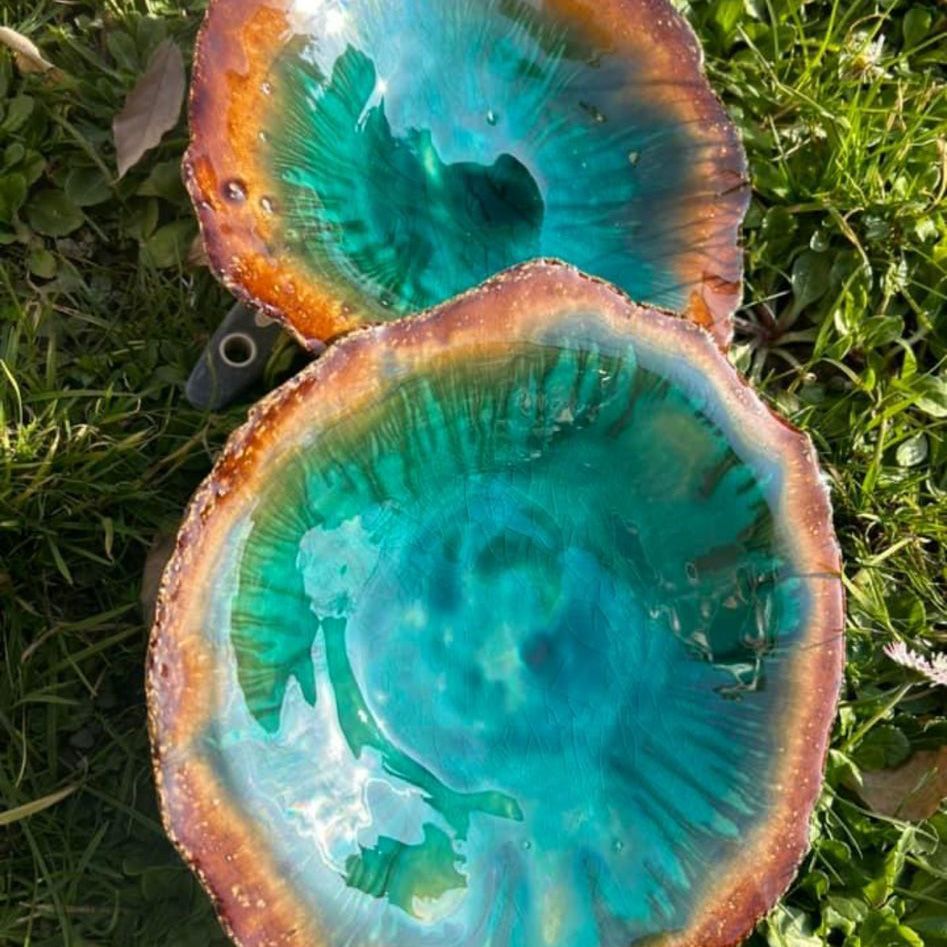 Zwei Schüsseln stehen übereinander im Gras.