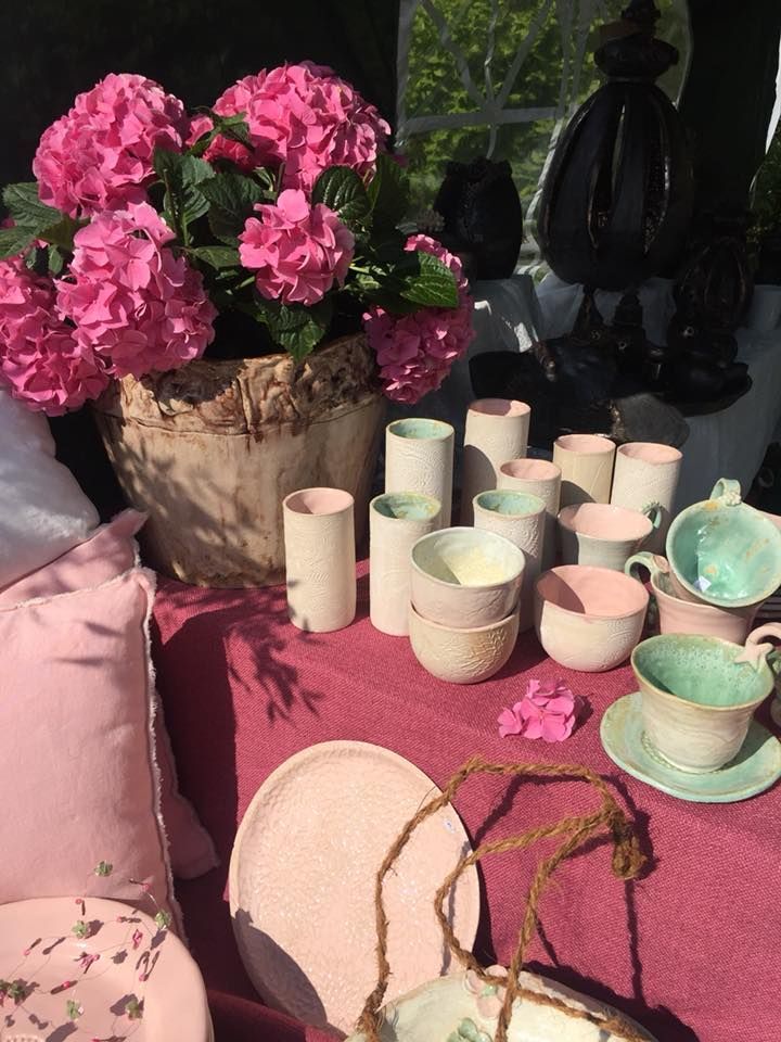 Ein Tisch mit rosa Blumen und Tassen und Untertassen darauf