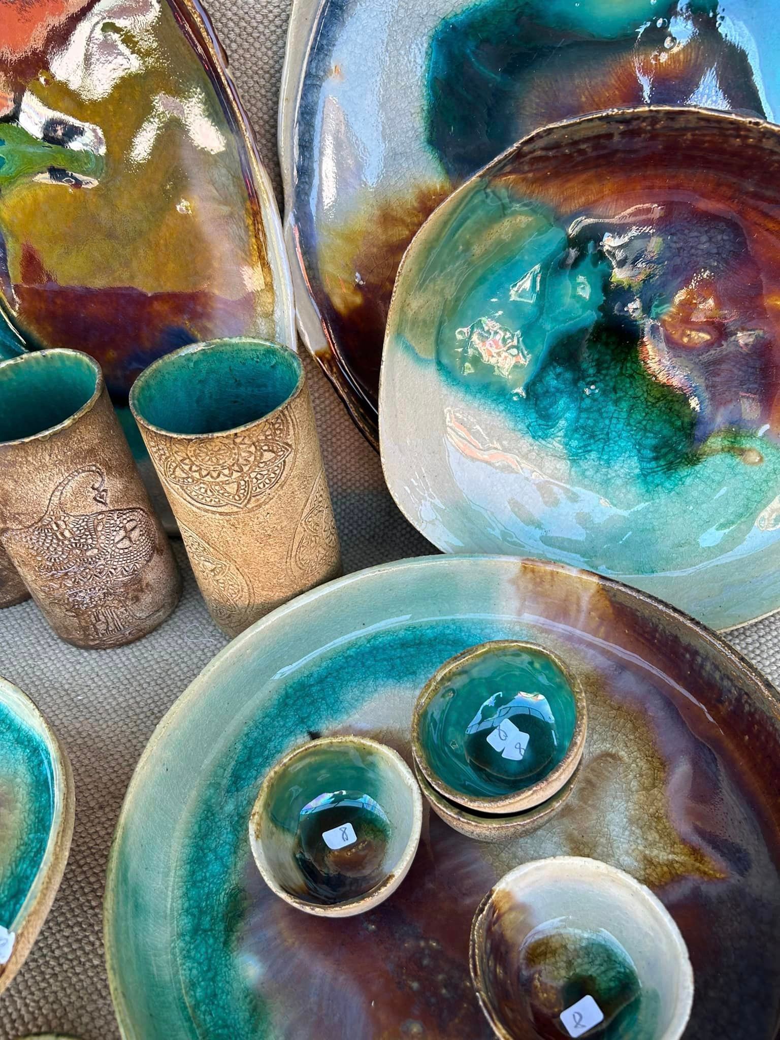 Auf einem Tisch stehen mehrere Keramikschüsseln und -tassen.