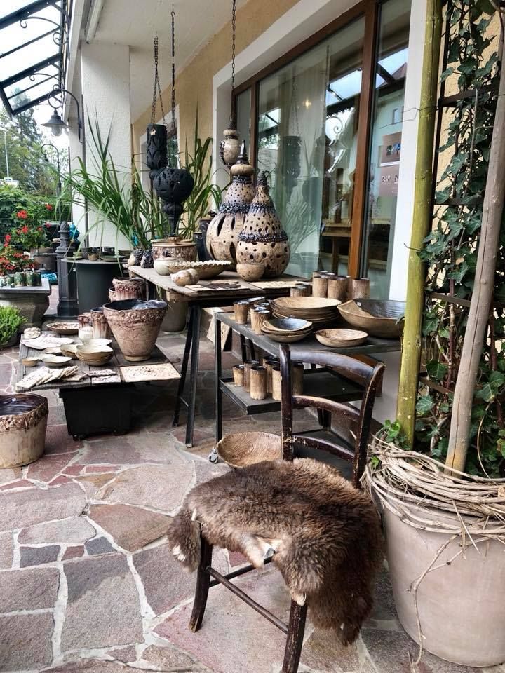 Eine Terrasse mit vielen Topfpflanzen und einem Stuhl.