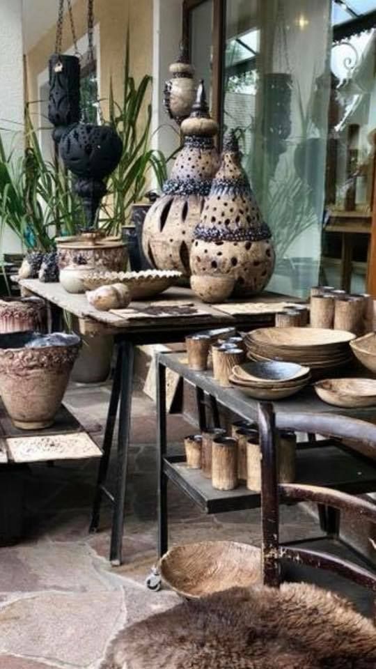 Ein Raum mit vielen Vasen und Schüsseln auf Tischen.