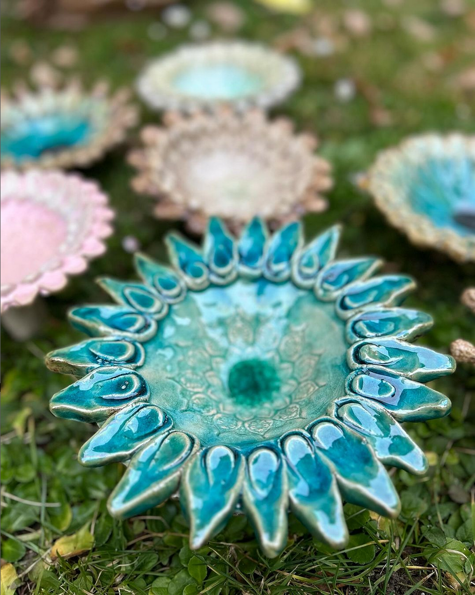 Eine Gruppe Keramikteller auf einem üppigen grünen Feld.