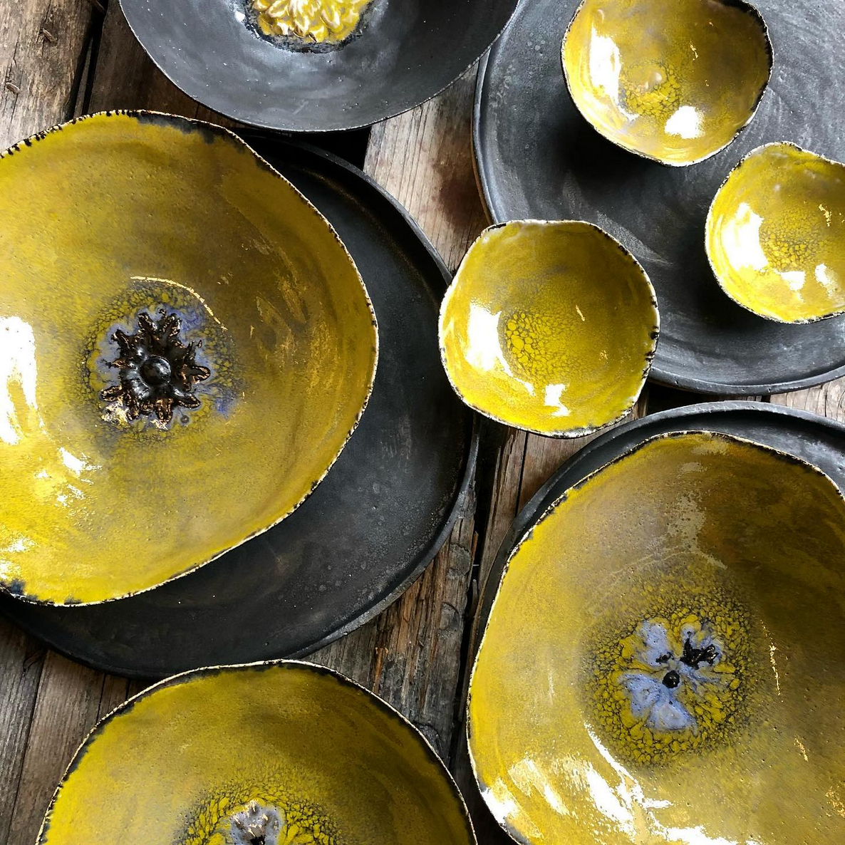 Eine Gruppe gelber Schüsseln und Teller auf einem Holztisch