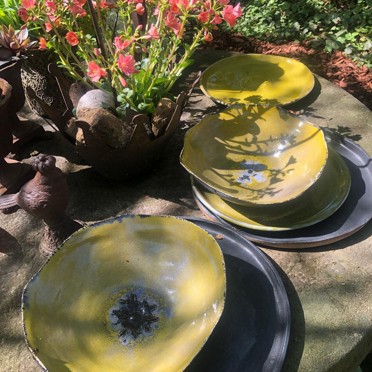 Ein Tisch mit Tellern und Schüsseln mit Blumen im Hintergrund