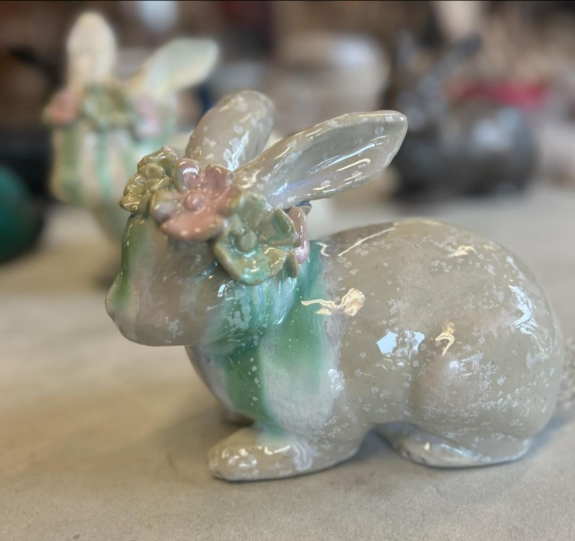 Ein Keramikhase mit einer Blumenkrone auf dem Kopf