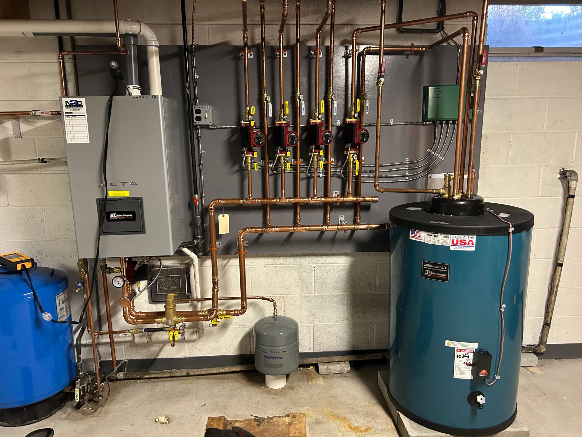 A Blue Water Heater is Sitting Next to a Boiler in a Basement