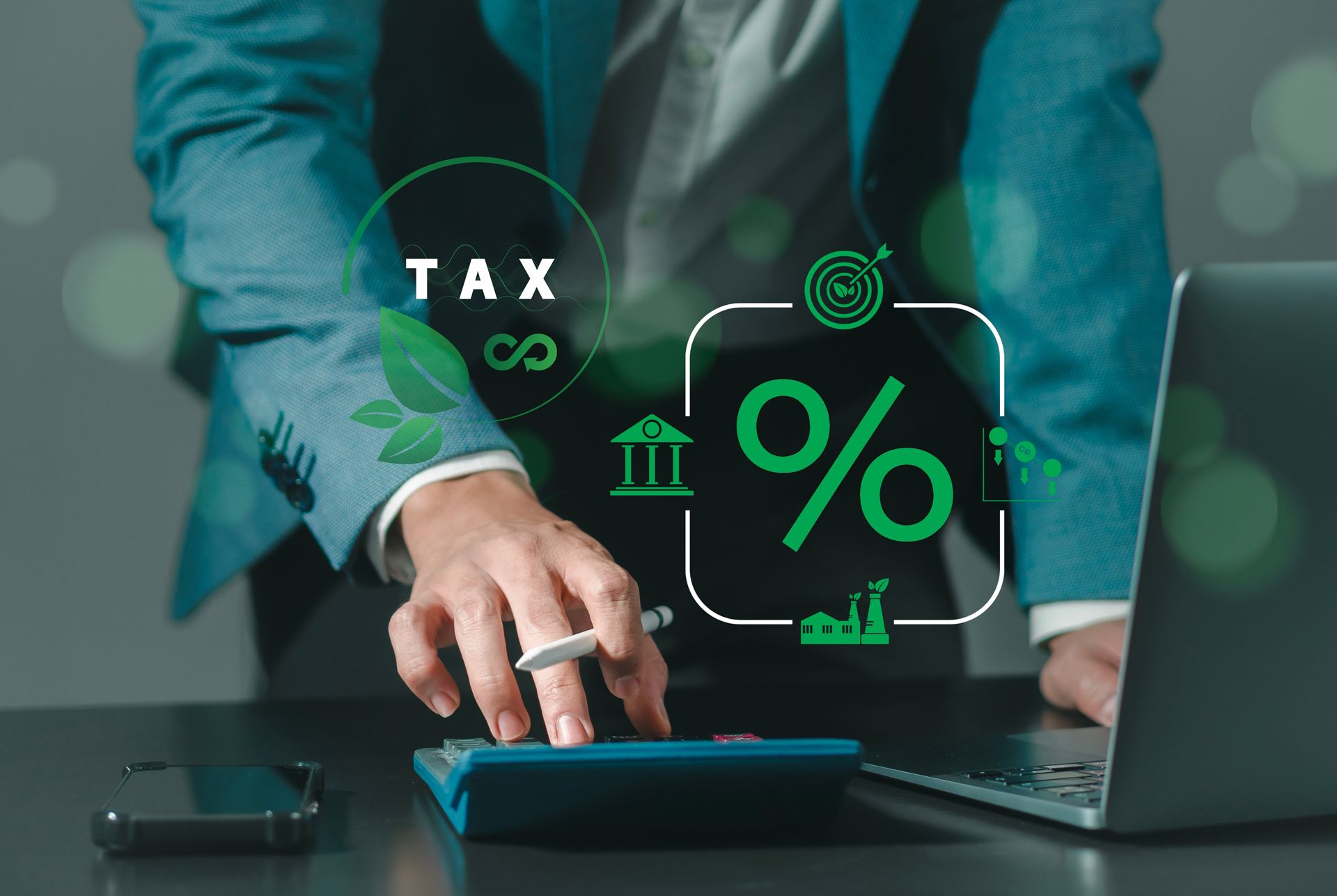 A Man is Using a Calculator in Front of a Laptop Computer