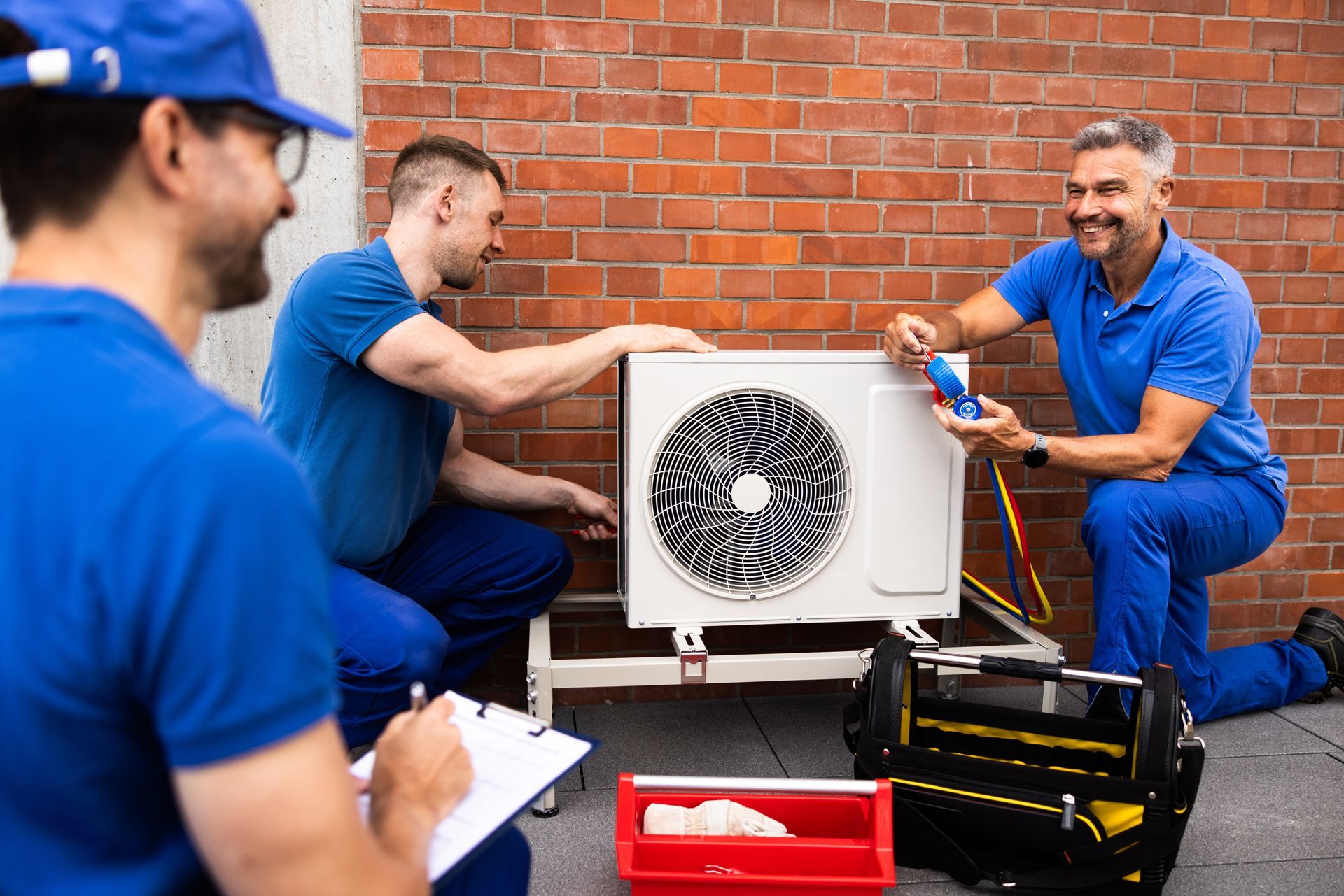 A Group of Men Are Working on an Air Conditioner