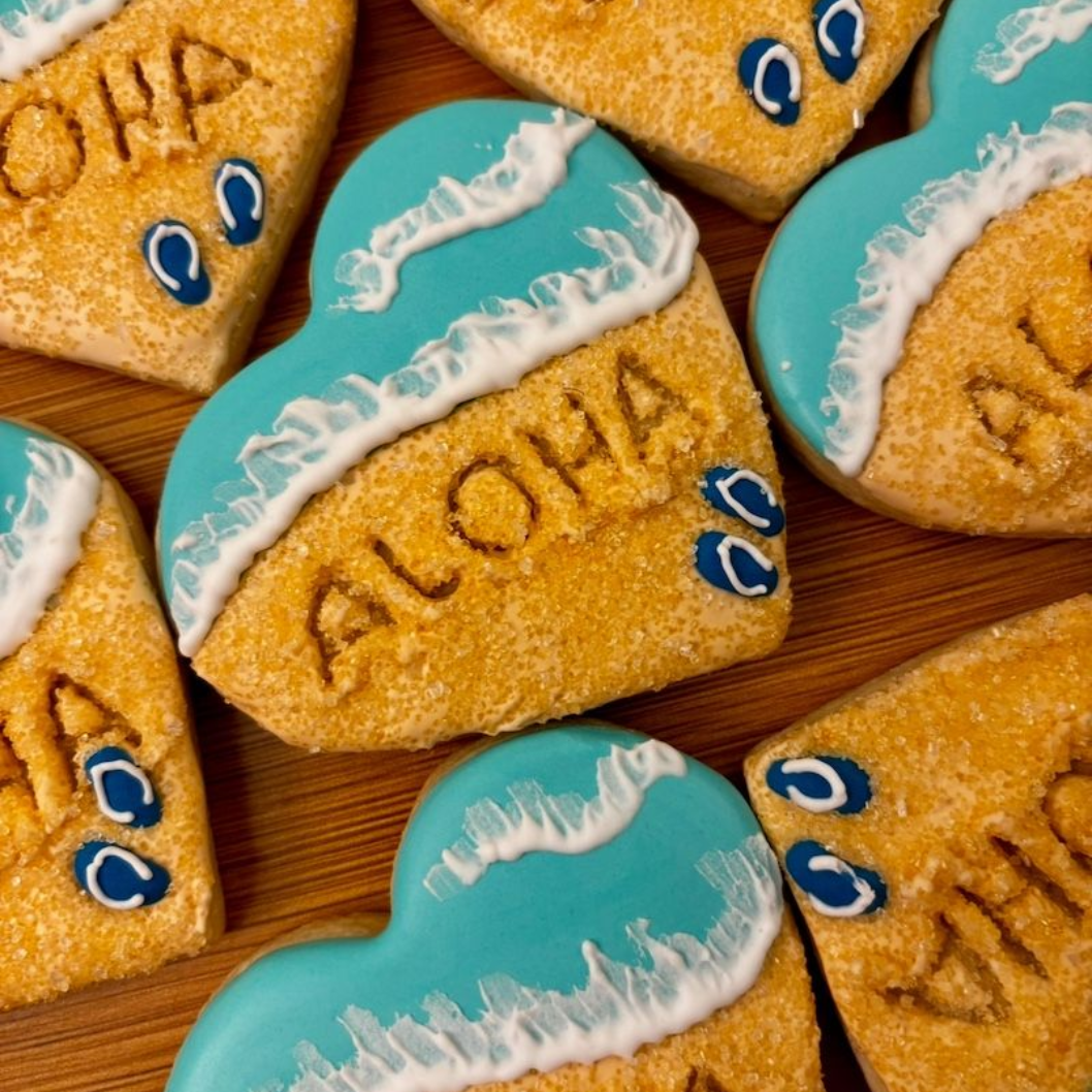 Heart-shaped sugar cookies decorated with sandy beach, blue waves, and 