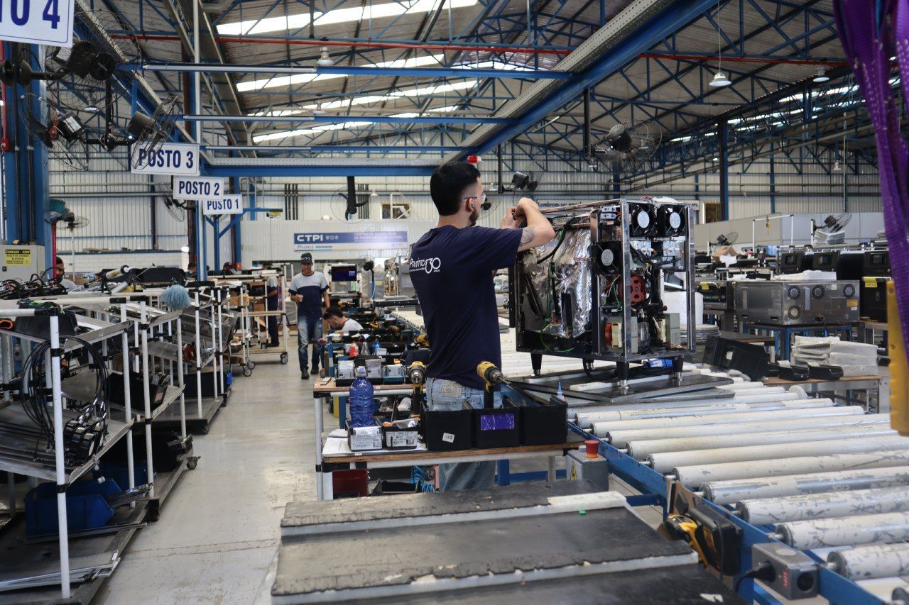 Um homem está trabalhando em uma máquina em uma fábrica.