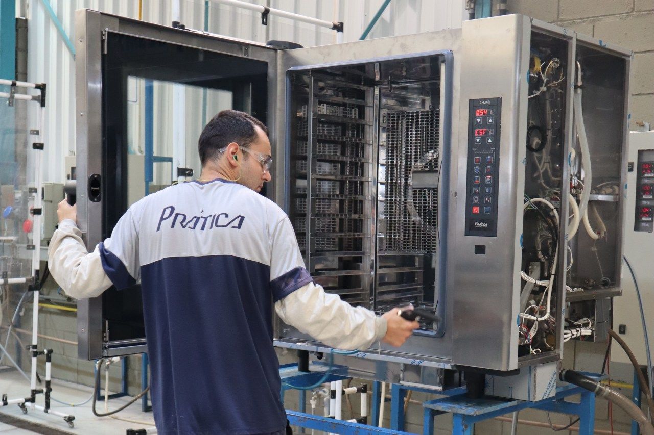 Um homem está trabalhando em um forno em uma fábrica.