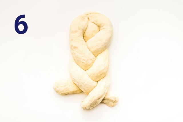 Um close de uma massa trançada em uma superfície branca.