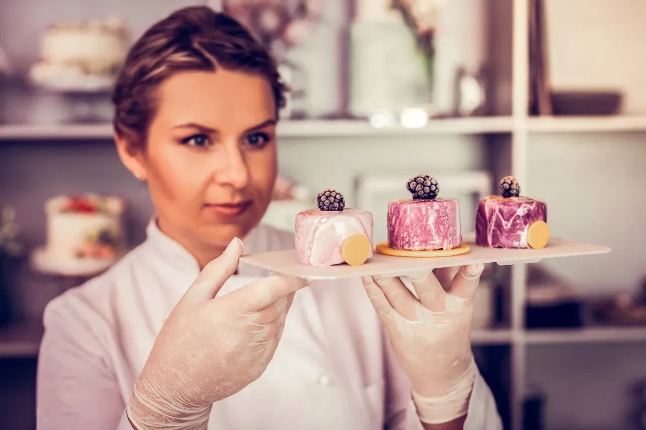 Confeiteira apresenta sobremesas individuais elaboradas em ambiente profissional