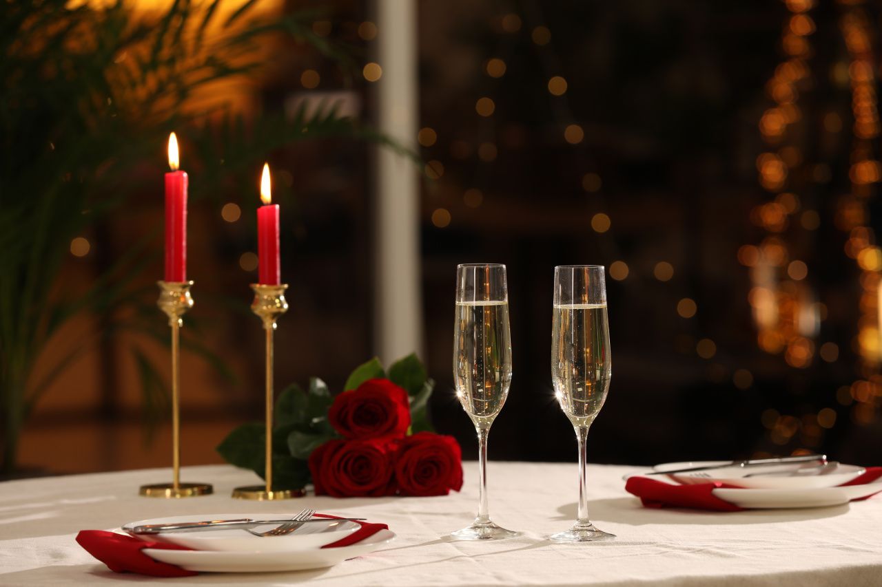 mesa com velas, taças de champagne e talheres