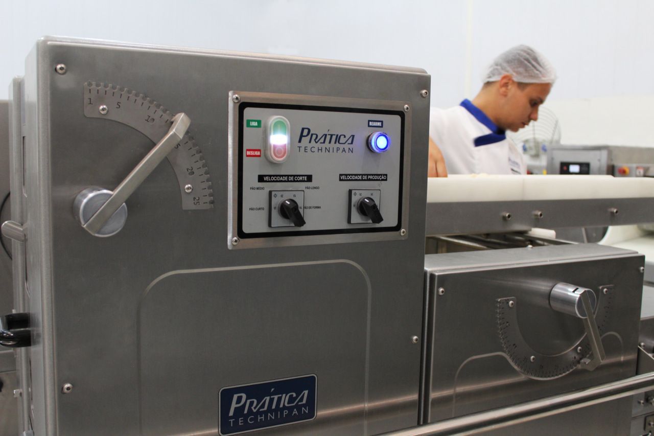 Um homem está trabalhando em uma máquina na cozinha.