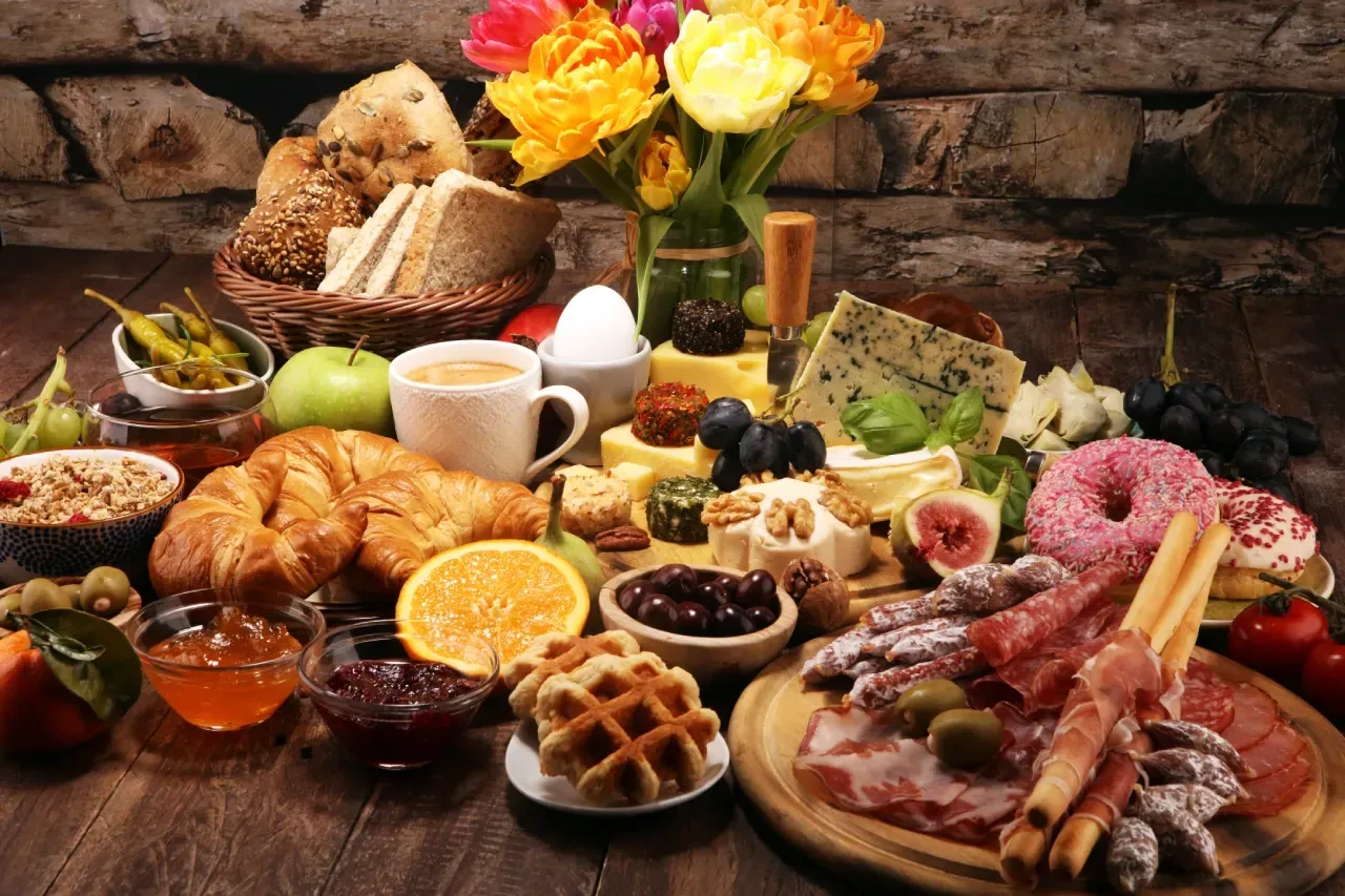 Brunch completo com diversos itens sobre mesa de madeira