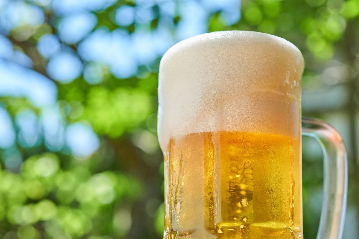 Um close de um copo de cerveja com a palavra pratica no canto