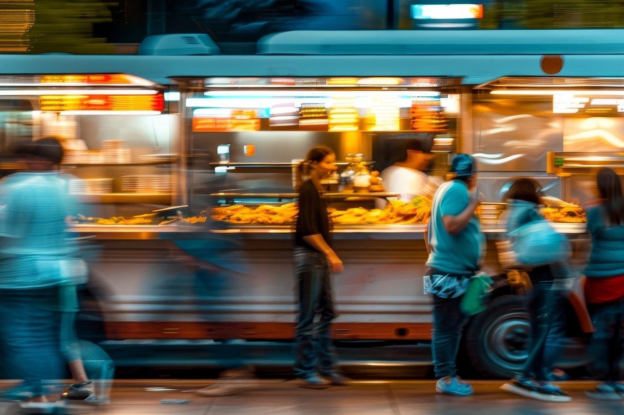 Um grupo de pessoas está em frente a um food truck.