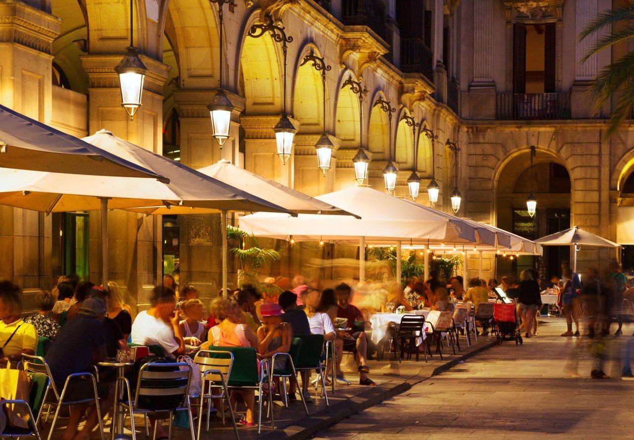 mesas de restaurante na rua a noite com pessoas na Europa