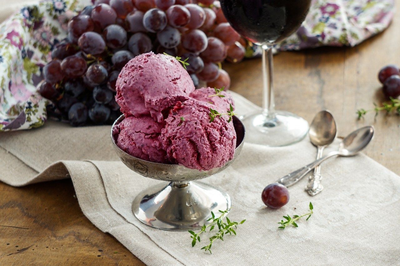 sorbet de uva servido em taça sobre a mesa com toalha e uvas 