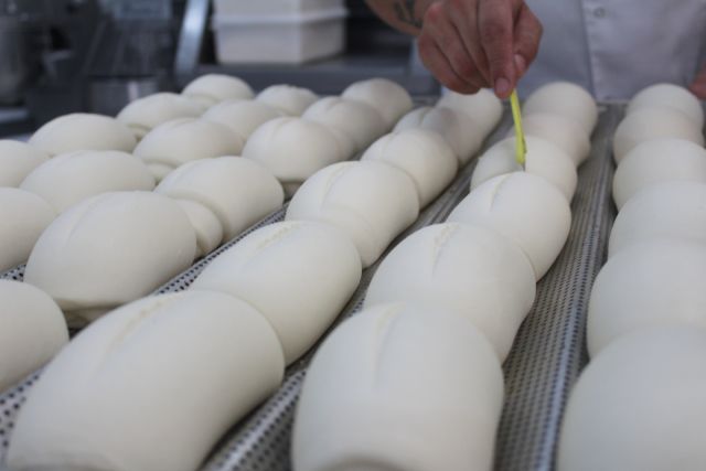 Uma pessoa está medindo um monte de massa em uma bandeja
